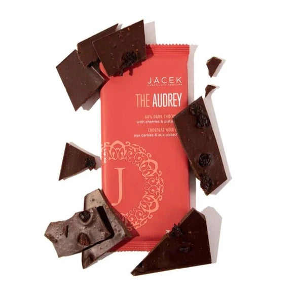 Meet Audrey, a dark chocolate bar with a twist. The Audrey loves to make a statement by taking time-honoured style and adding a little extra flourish. Like a bold statement necklace, this exotic dark chocolate bar is elegantly adorned with dried cherries & pistachios. The Base: 64% Dark chocolate (vegan) The Embellishments: Dried cherries & toasted pistachios Weight: 70g This product is shelf-stable. Please store in dry, cool place. Contains: Nuts, Soy. May contain: Milk, P