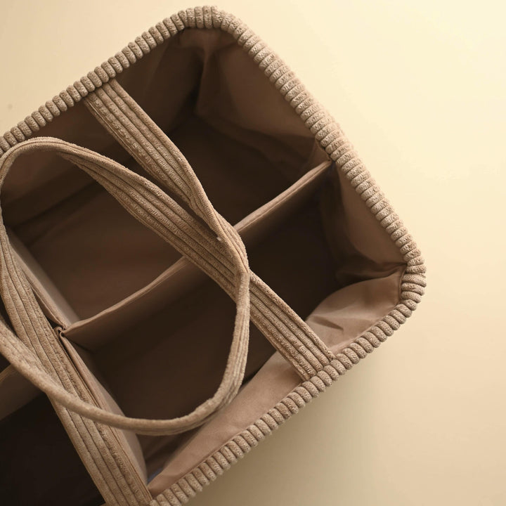 Beige fabric organizer with compartments on a beige background