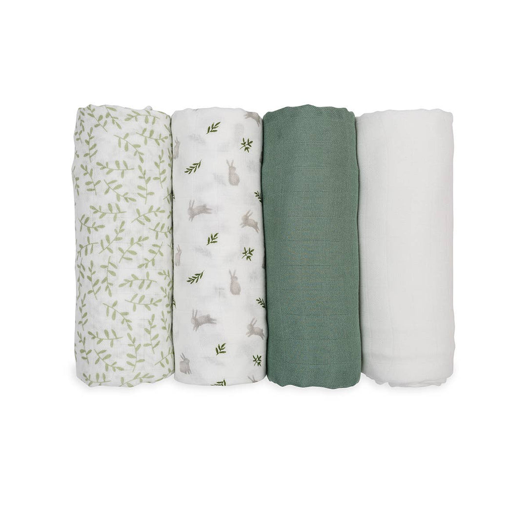Four rolled muslin baby swaddle blankets in different colors and patterns, arranged in a row on a solid white background. The set includes a white swaddle with green leaf prints, a white swaddle with gray bunny prints, a sage green solid swaddle, and a solid white swaddle.