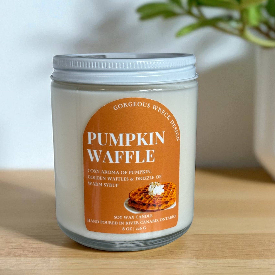 A 6 oz soy wax candle in a clear glass jar with a white lid, featuring an orange label that reads &