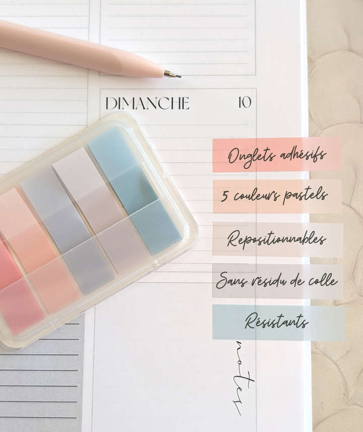 Set of pastel-colored adhesive notes with a pen on a white surface