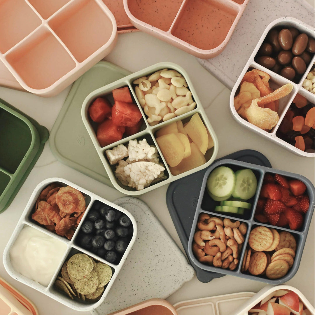 Assorted bento boxes with a variety of food items on a light surface.