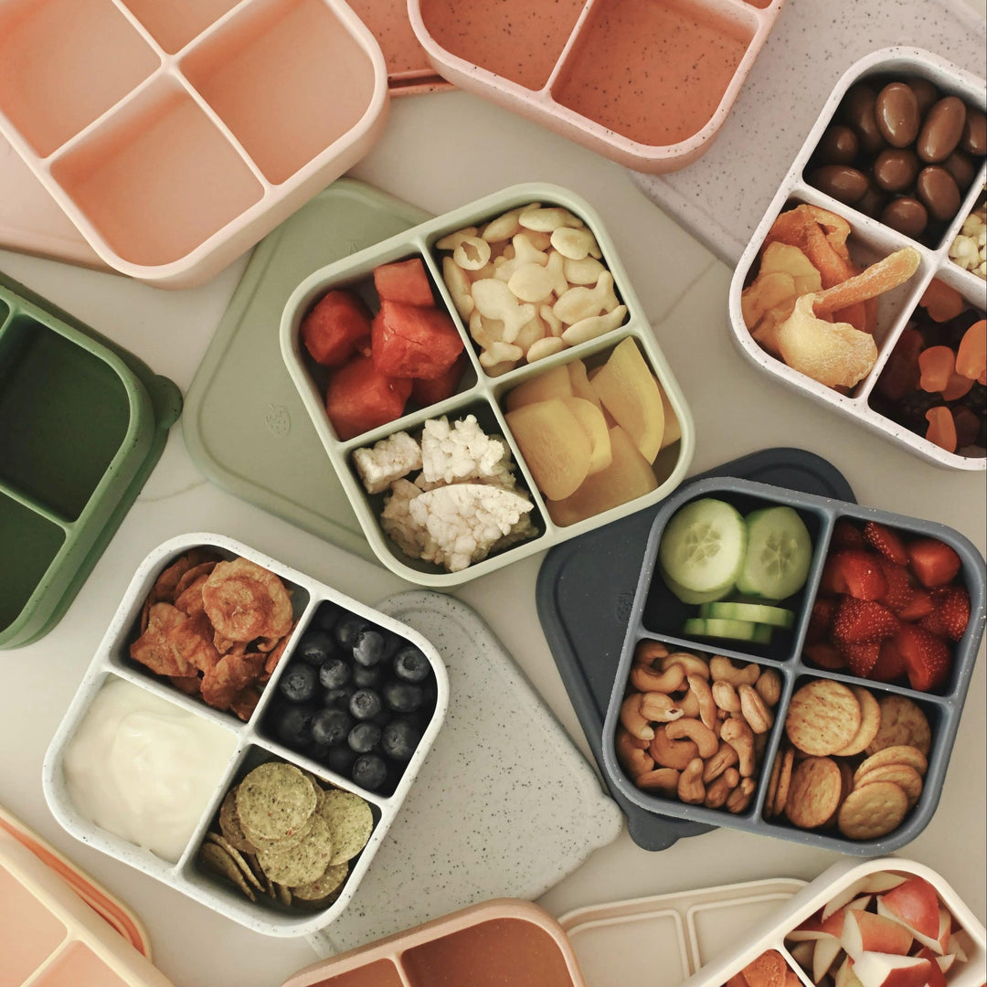 Assorted bento boxes with a variety of food items on a light surface.