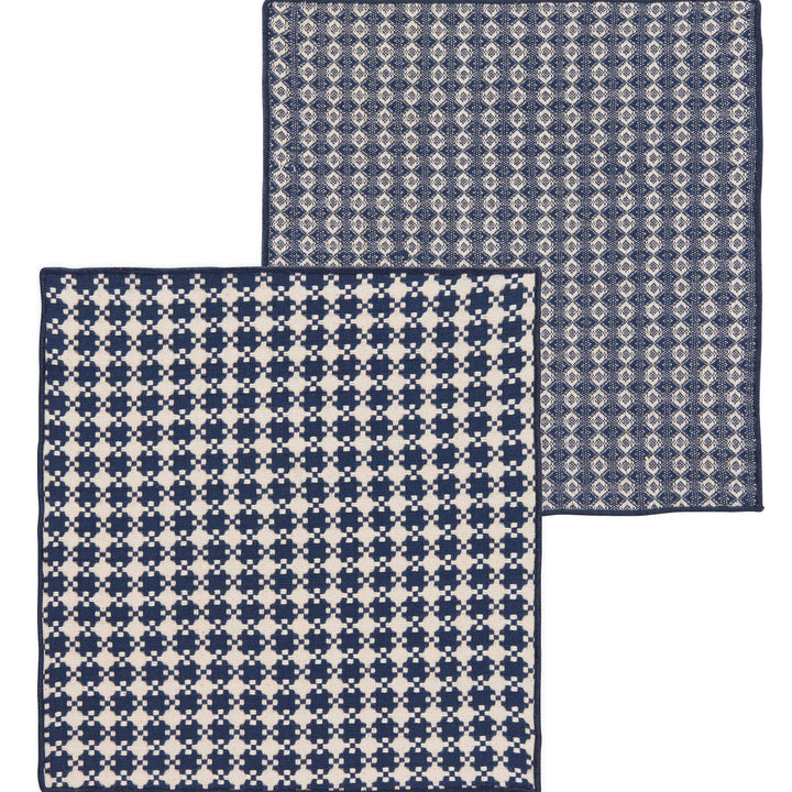 Two square woven fabric pieces with geometric patterns, shown overlapping on a plain white background. One has a navy and off-white houndstooth-like pattern, and the other has a navy and off-white diamond lattice pattern.