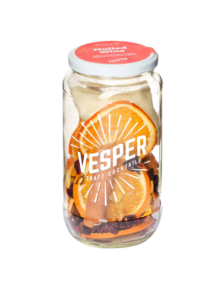 Vesper craft cocktail jar with orange slices and a red lid on a white background