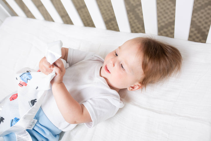 Two Lulujo Baby cotton security blankets with hockey-themed designs, soft and cozy for babies.
