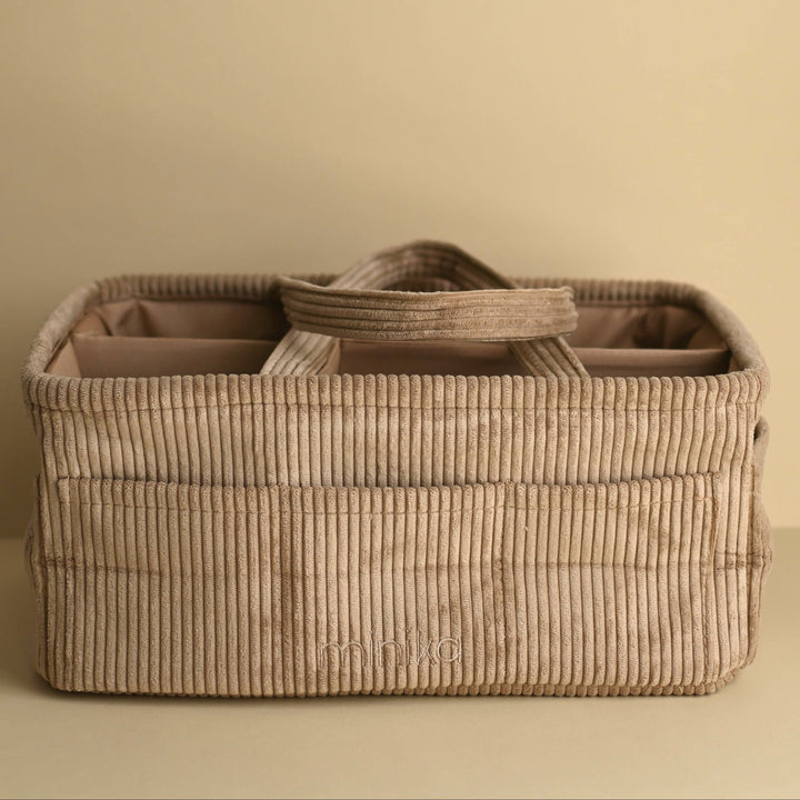 Beige woven basket with a handle on a beige background