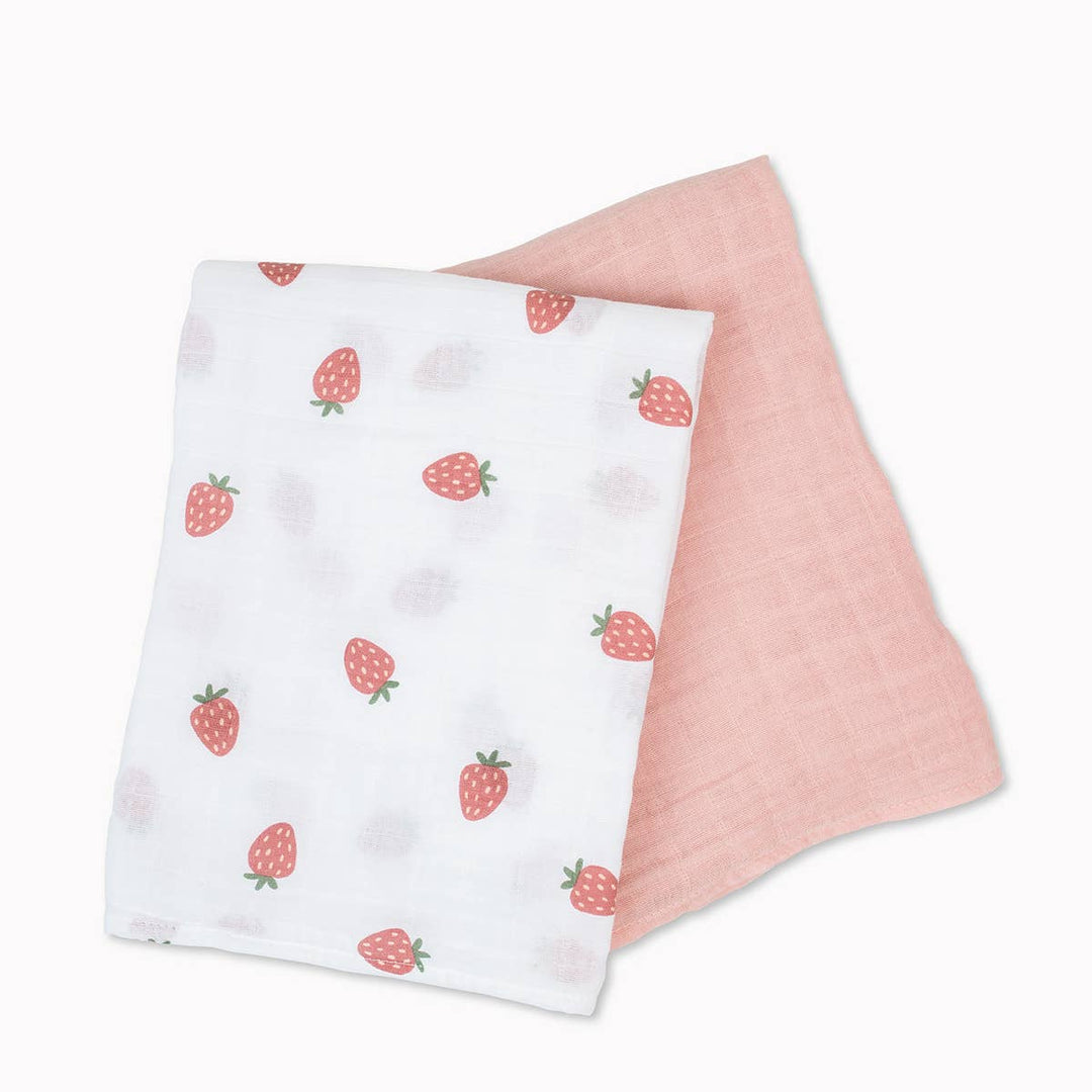 Two Lulujo Baby cotton swaddle blankets featuring strawberry and ballet slipper patterns for infants, soft and cozy for baby comfort.
