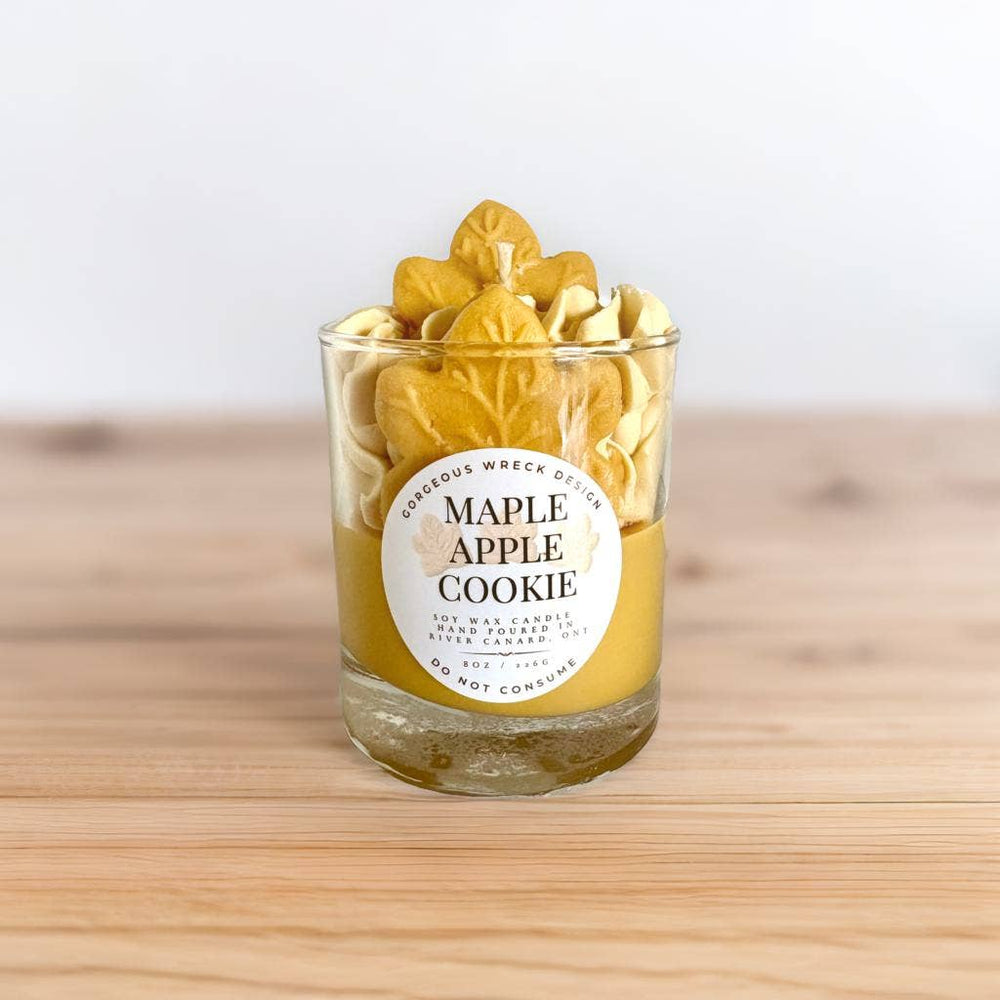 Glass candle with 'Maple Apple Cookie' label on a wooden surface