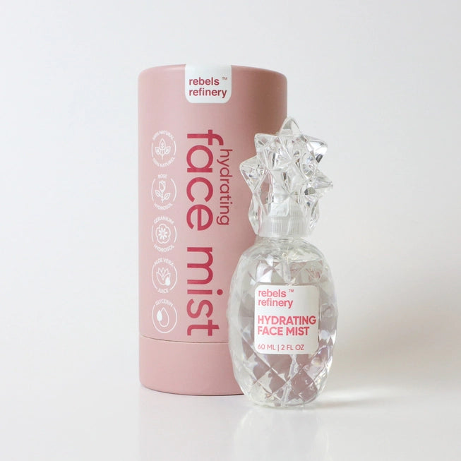 A pink hydrating face mist product with a clear bottle and a label that reads 'FACING MIST' and 'HYDRATING FACE MIST' from Rebels Refinery.