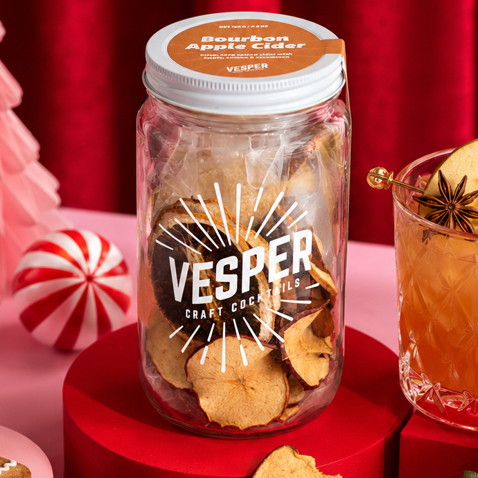 Vesper Cider with apple chips and festive decorations on a red background