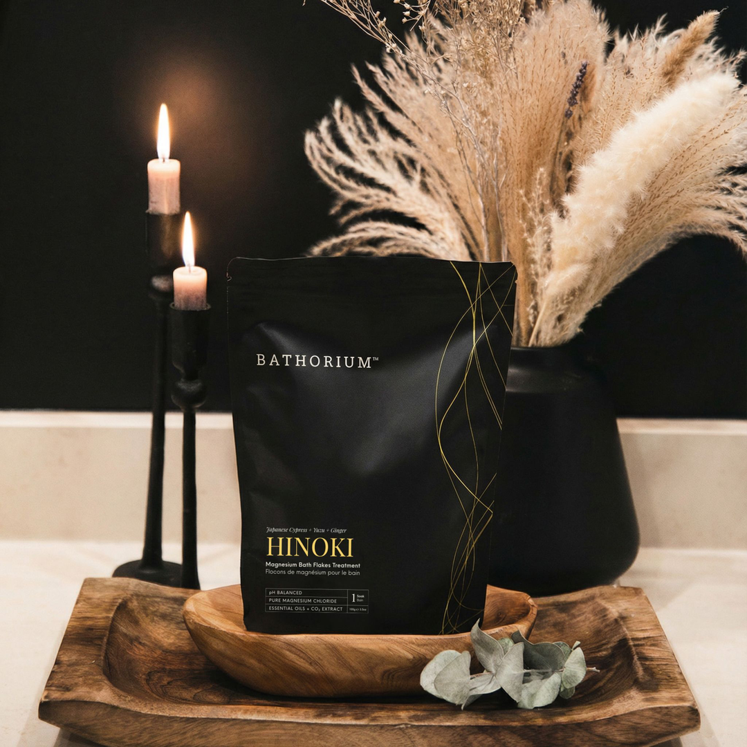 Bathorium Hinoki product packaging on a wooden tray with candles and dried plants in the background.