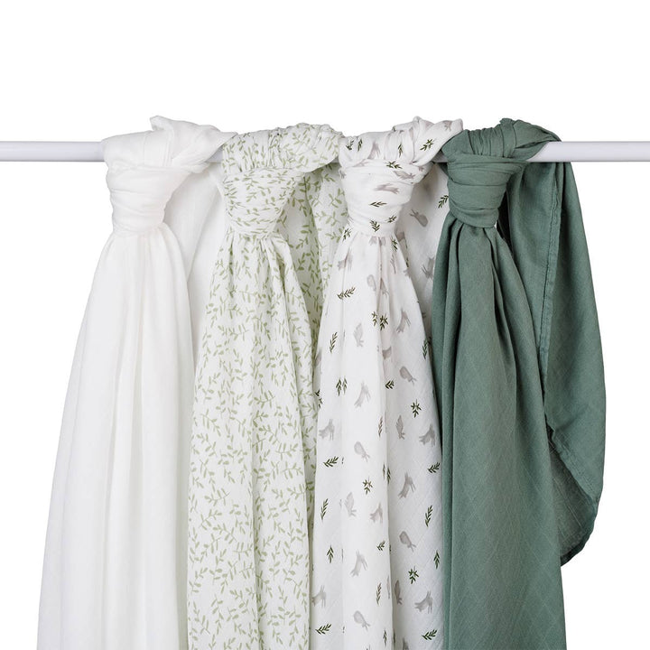 Set of four baby swaddles in white, green, and patterned designs on a white background
