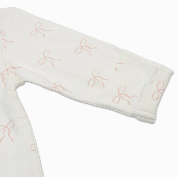 White baby blanket with pink bows on a white background