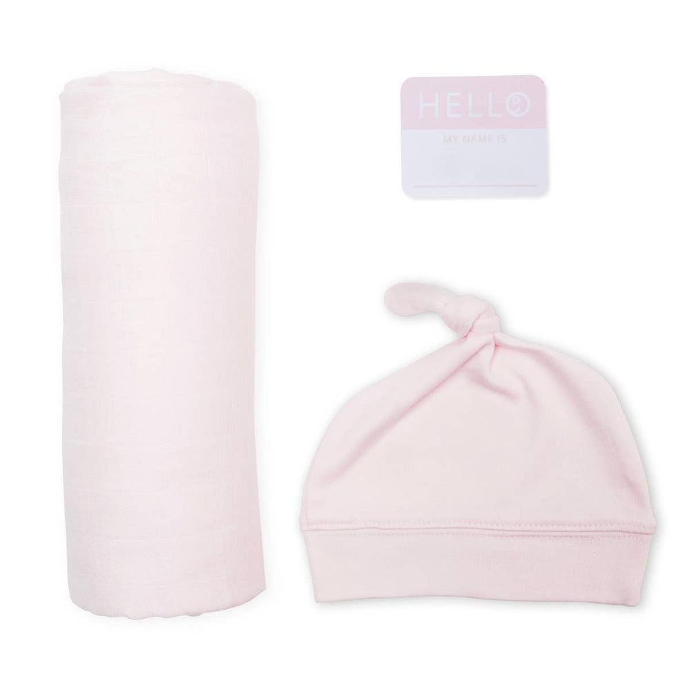 Pink baby hat and swaddle blanket with 'HELLO' card on a white background