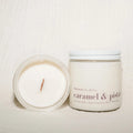 Candle and its container labeled 'caramel & pistachio' on a light background