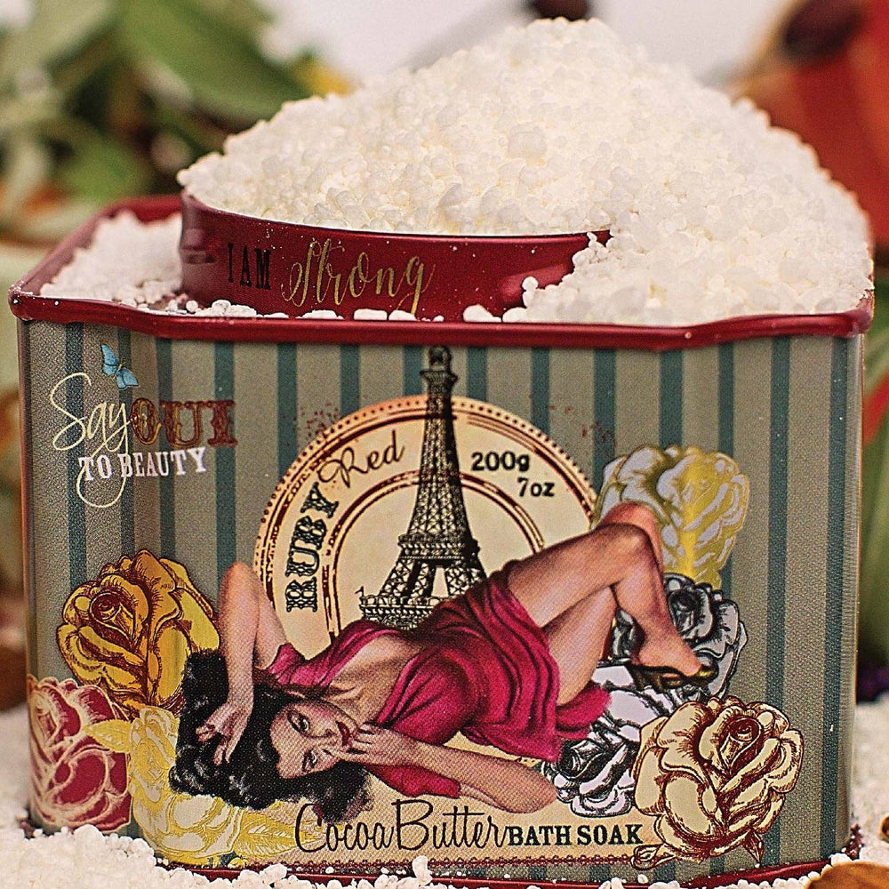 Barefoot Venus Ruby Red Bath Soak in a spa setting, showing the vibrant red bath salts in a clear bowl with a wooden spoon.
