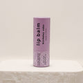 Lip balm tube labeled 'birthday cake' on a light beige background