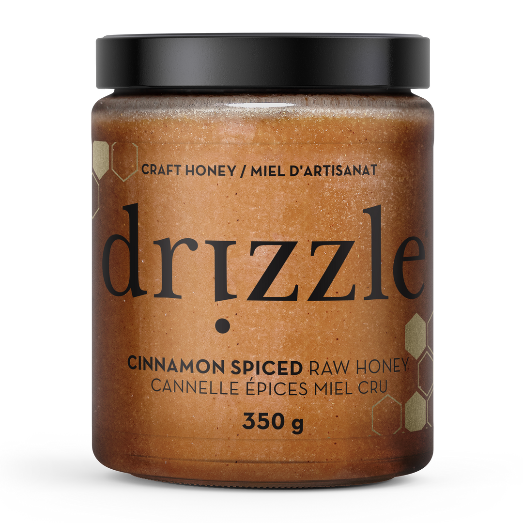 Jar of drizzle cinnamon spiced raw honey on a white background