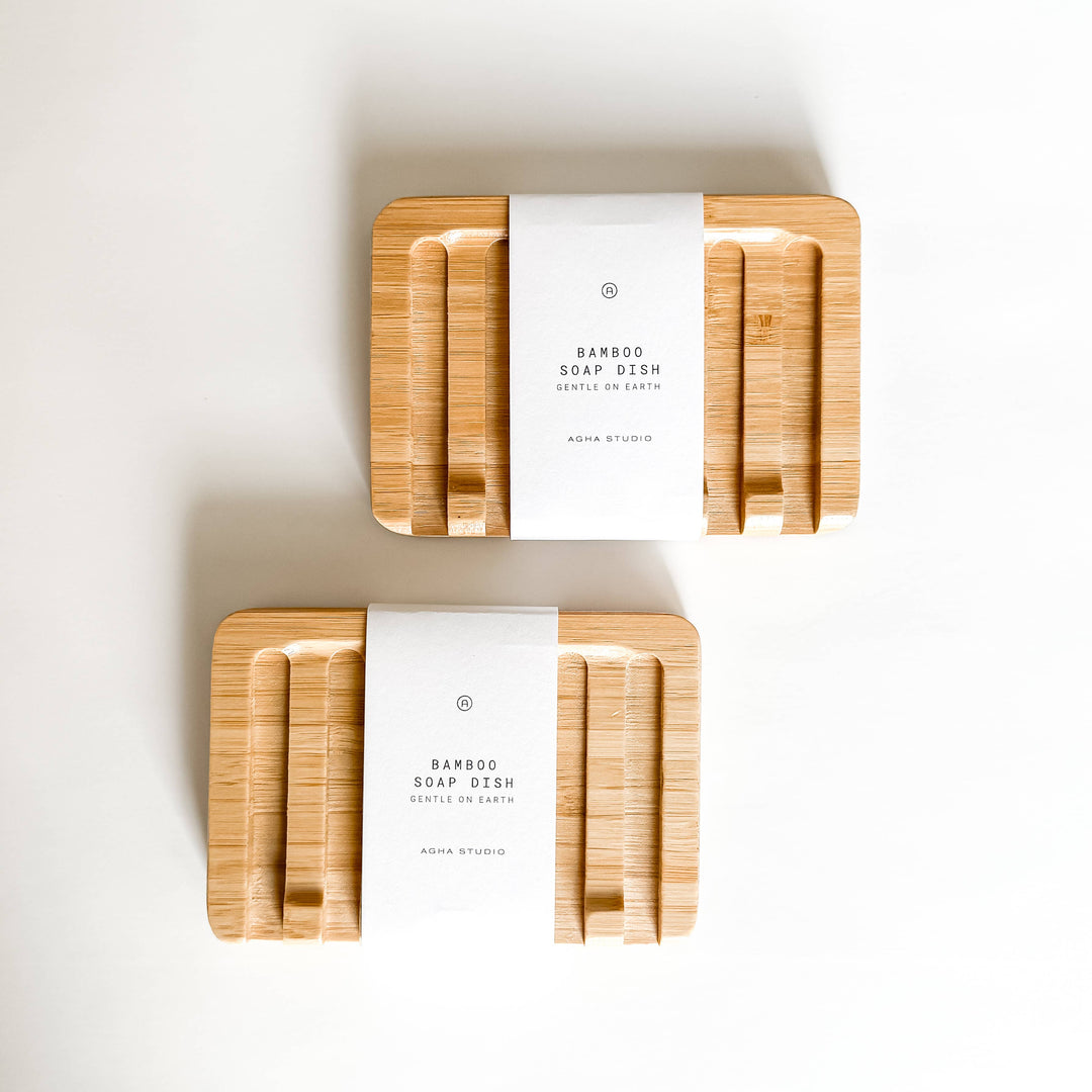 Two bamboo soap dishes with white labels on a light background