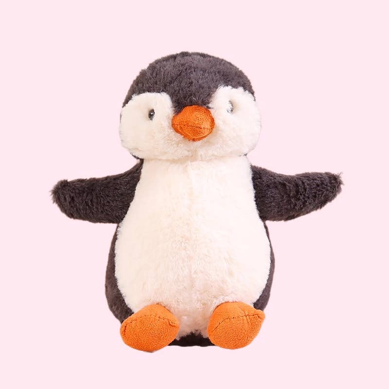 Stuffed penguin toy with orange feet and beak on a light pink background