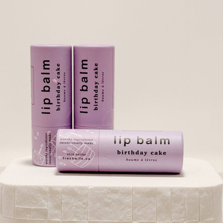 Lip balm packaging with 'birthday cake' flavor on a light background