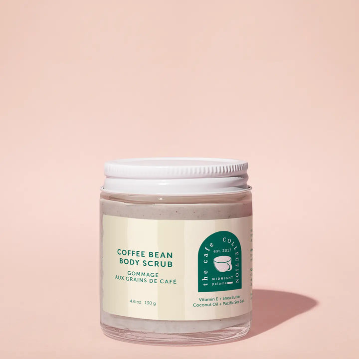 A clear jar containing a coffee bean body scrub with a white lid and a label that reads 'Coffee Bean Body Scrub'.