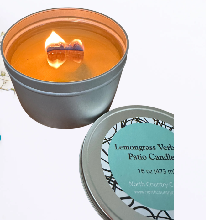 Candle in a tin with a label and decorative elements on a light background