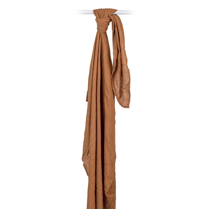 Brown scarf draped over a white rod on a white background