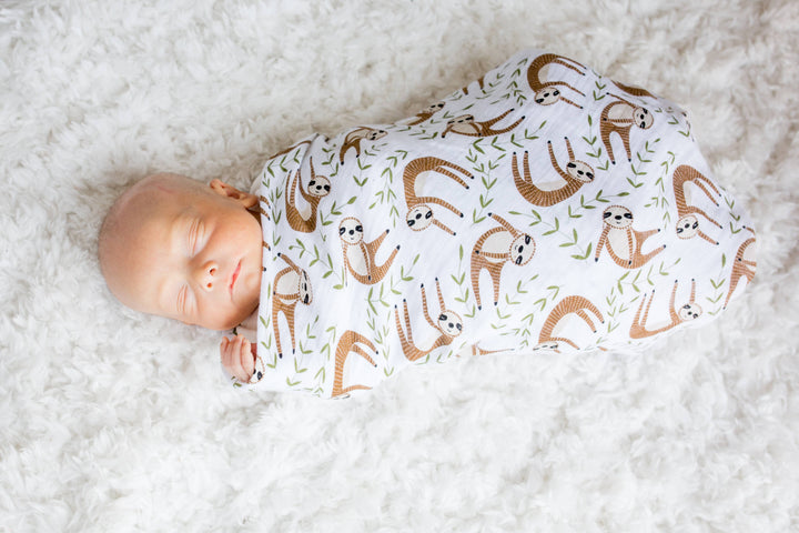Soft muslin cotton swaddle blanket featuring a cute sloth print, ideal for babies and made by Lulujo Baby.