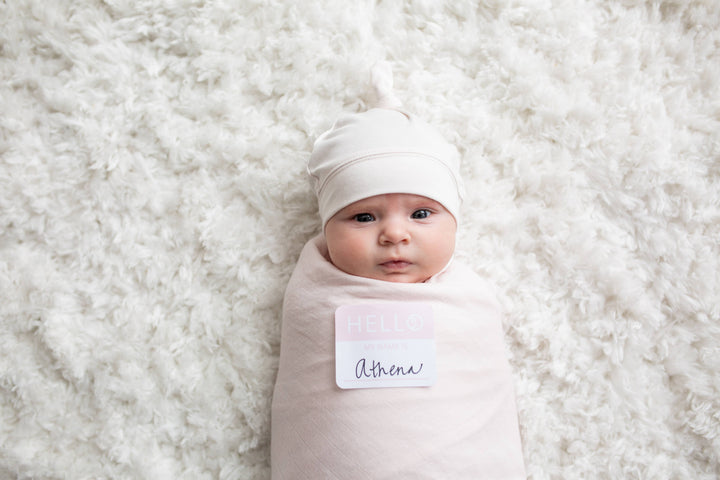 Baby wrapped in a light pink blanket with &