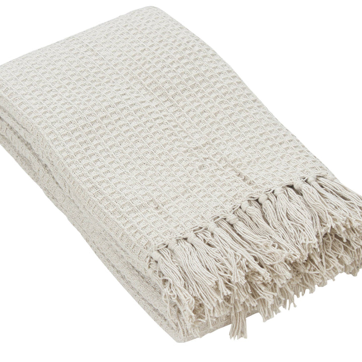 Beige woven throw blanket with fringes on a white background