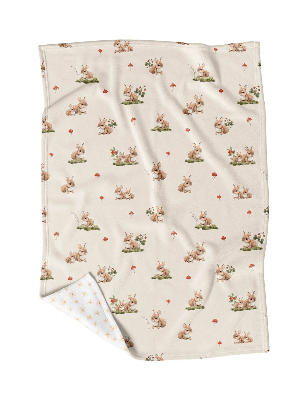 A cream-colored blanket with an all-over print of cute rabbits, small red hearts, and tiny green plants, shown with one corner folded over to reveal the white reverse side with a subtle pattern.