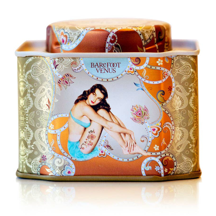 Decorative tin with 'Barefoot Venus' branding on a white background