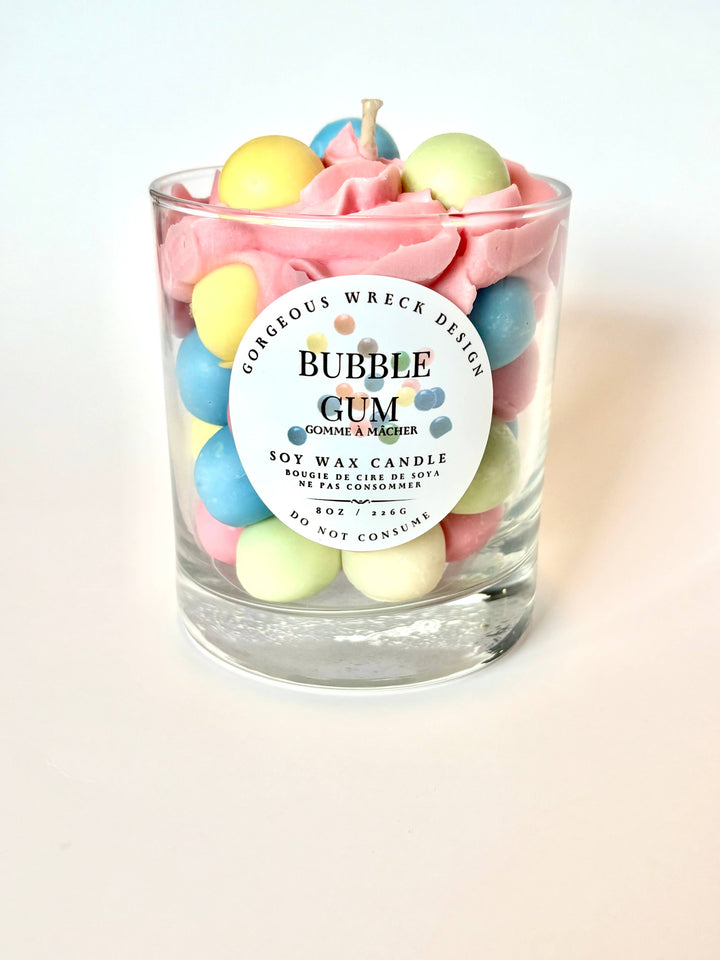 Bubble gum-themed candle with colorful gumball decorations on a light background