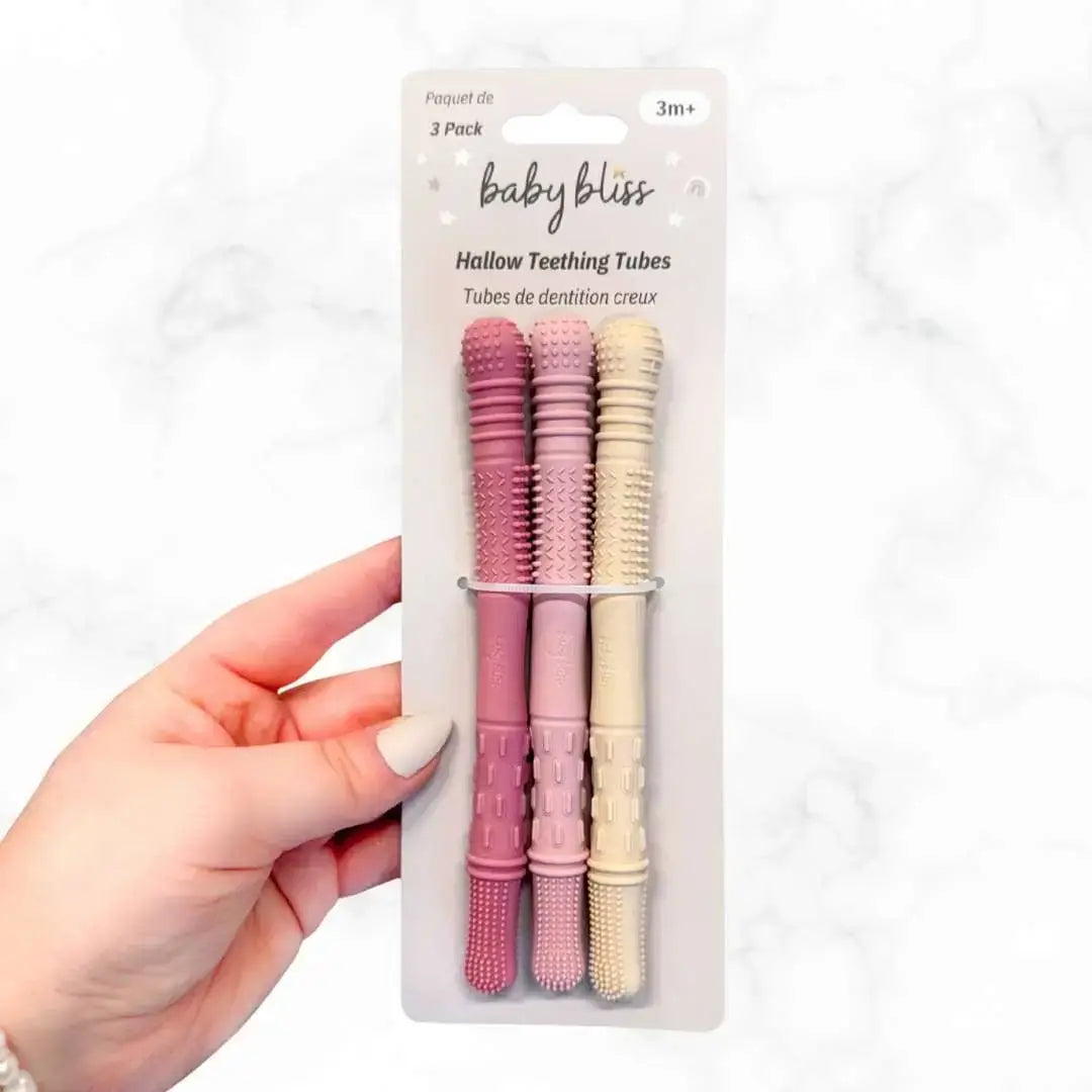 Hand holding a package of baby teething tubes with &