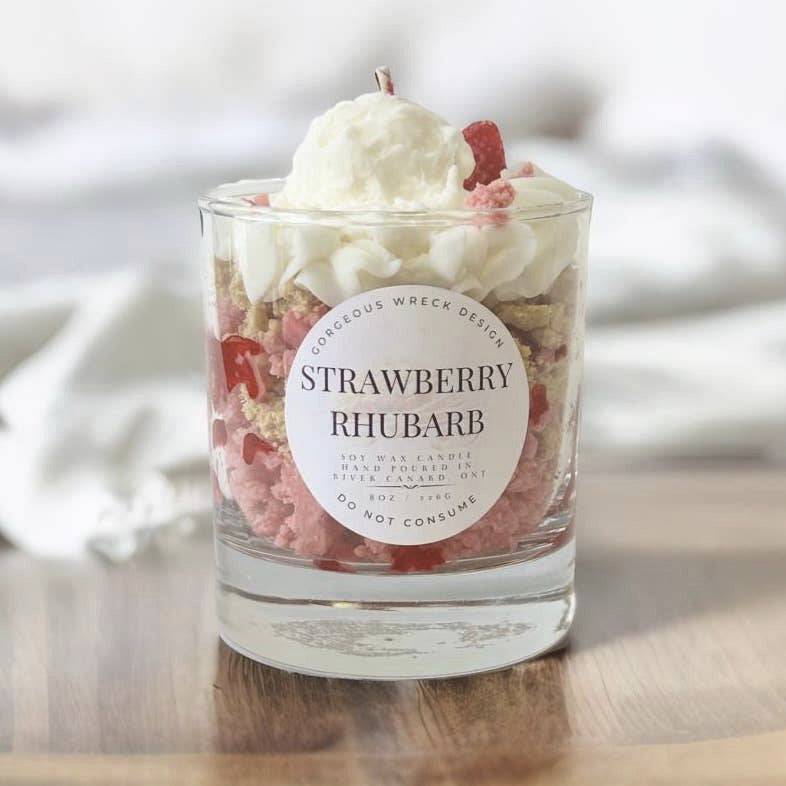 Strawberry rhubarb candle with whipped cream and gummy bears on a wooden surface