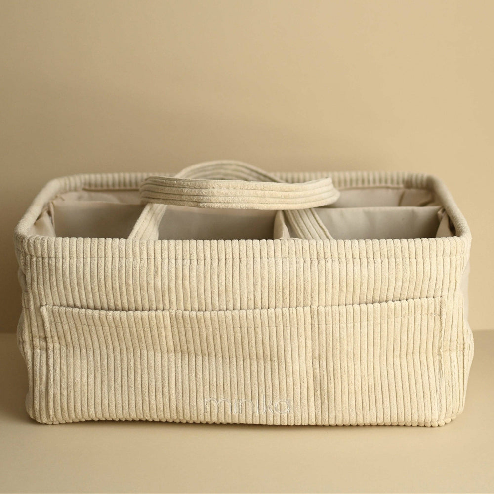 Beige woven storage basket with compartments on a beige background