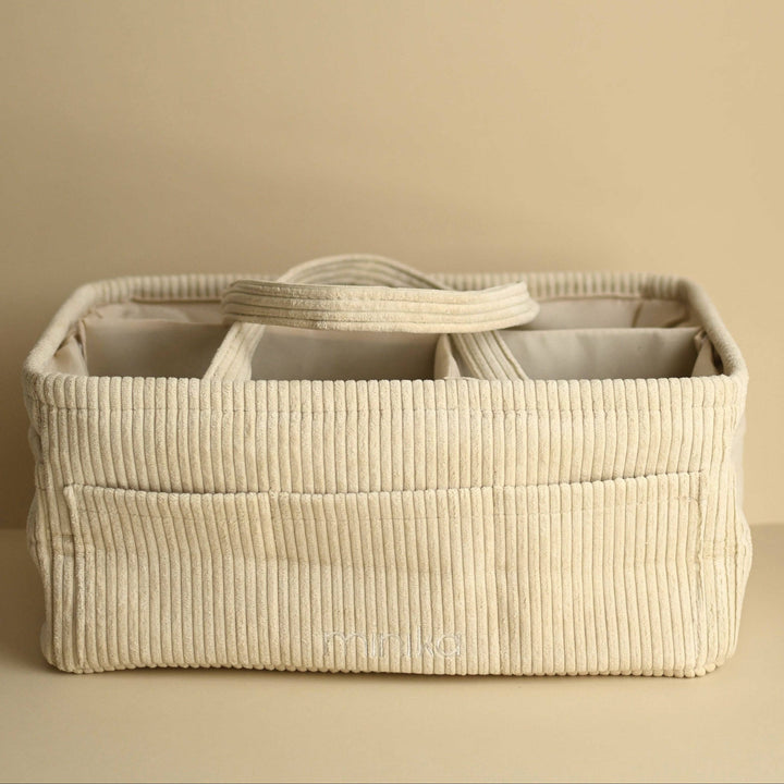 Beige woven storage basket with compartments on a beige background