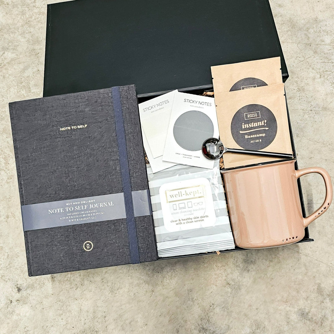 Curated for the discerning individual, this gift box combines elegance and functionality with items including a black linen journal from Wit & Delight, stylish sticky notes/page markers from Rosie Papeterie, a chic beige enamel look mug, Rosso Coffee's exquisite instant coffee packages, practical screen wipes from Well-Kept, a sleek black coffee spoon, all beautifully packaged in a Lux Box with hand-packing and a personalized handwritten note card.