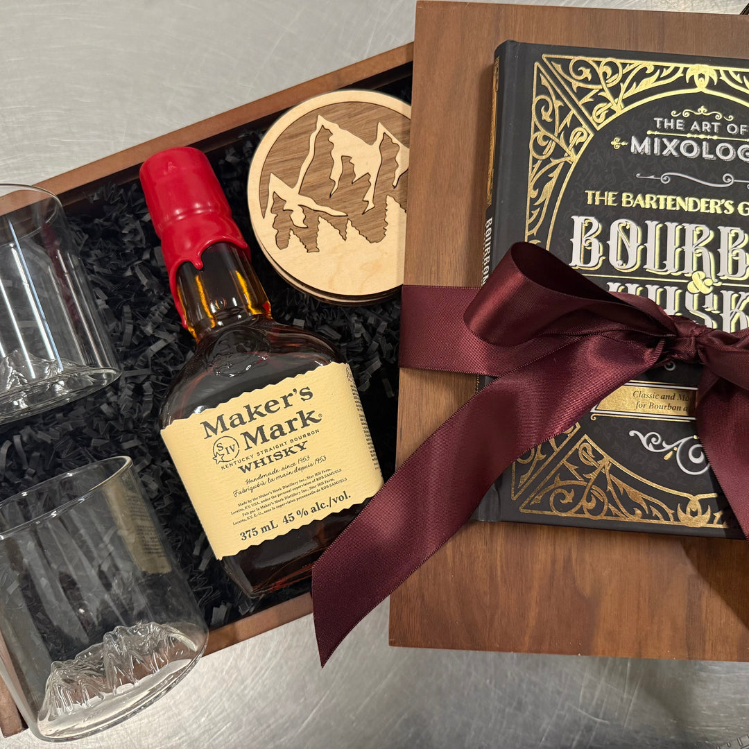 Bourbon gift set with Maker's Mark whiskey, glasses, and a book on mixology.