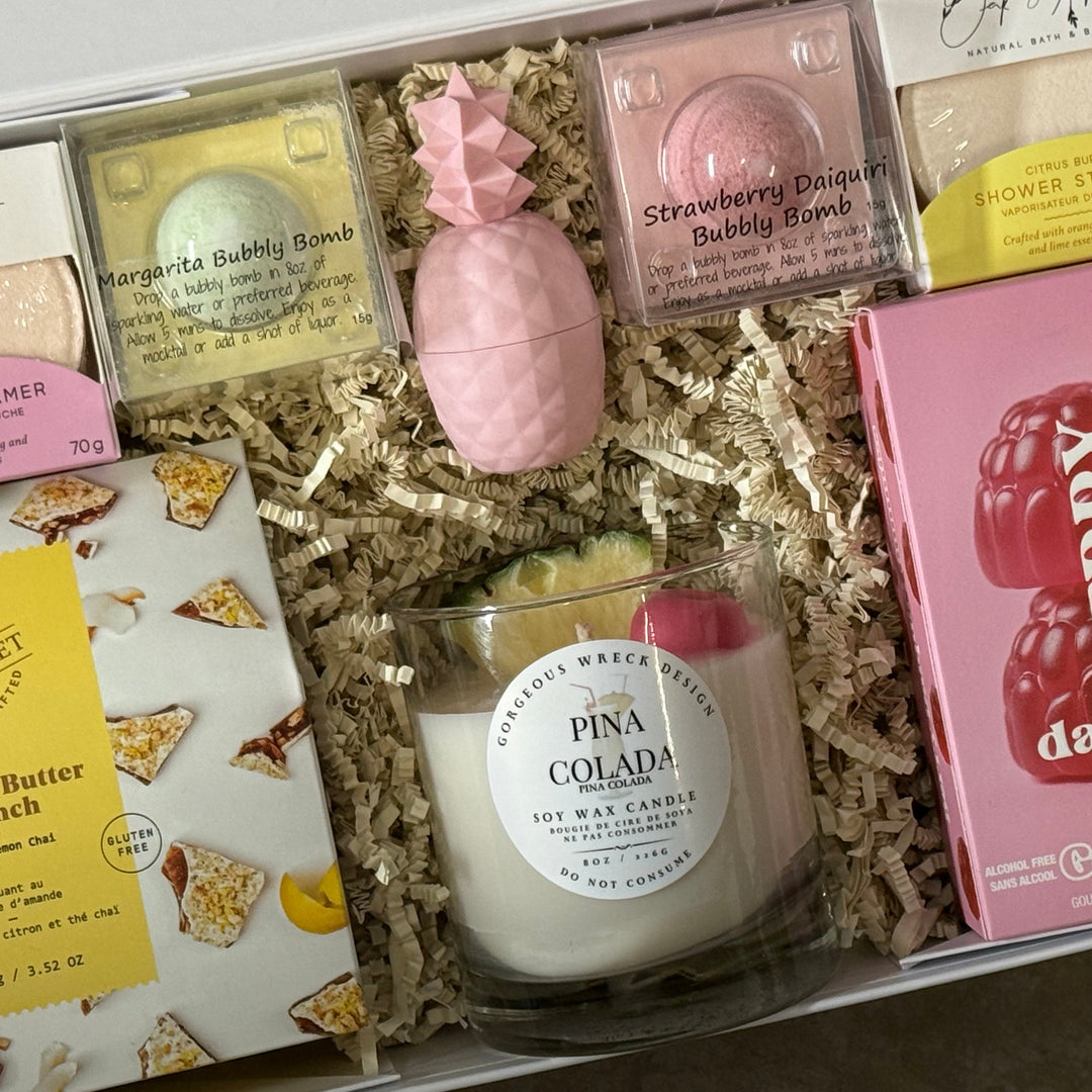 Assorted items including a candle, bath bombs, and gummies in a decorative box.