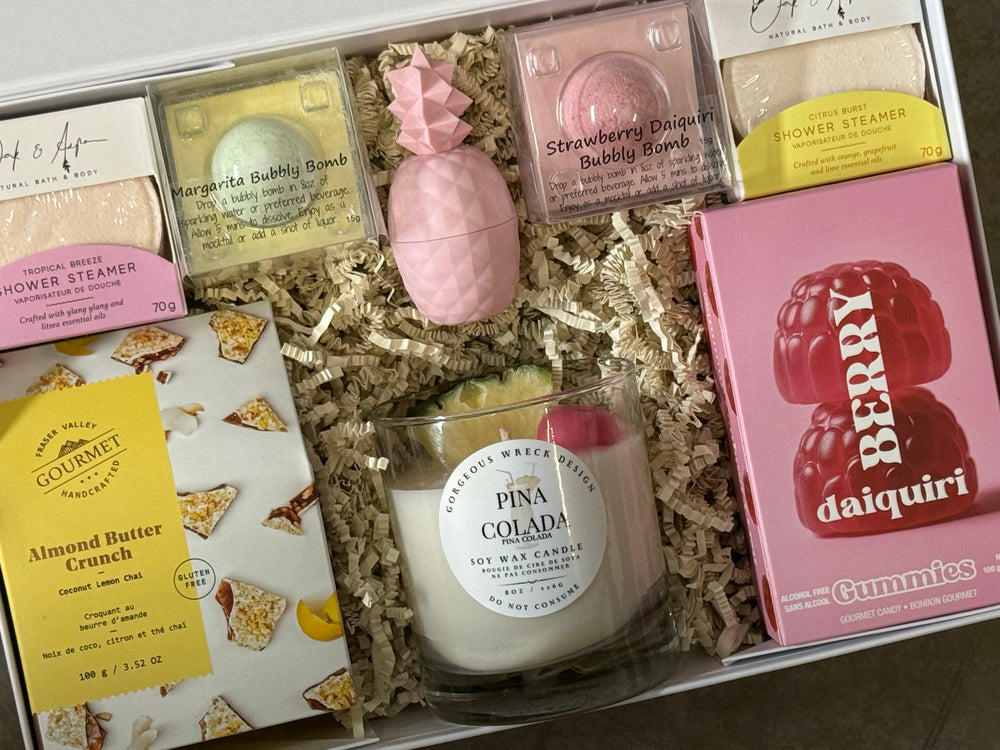 Assorted items including a candle, bath bombs, and gummies in a decorative box.