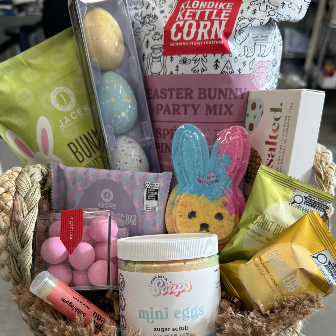 Gift basket with Easter-themed items including candy and a mug on a metal surface.