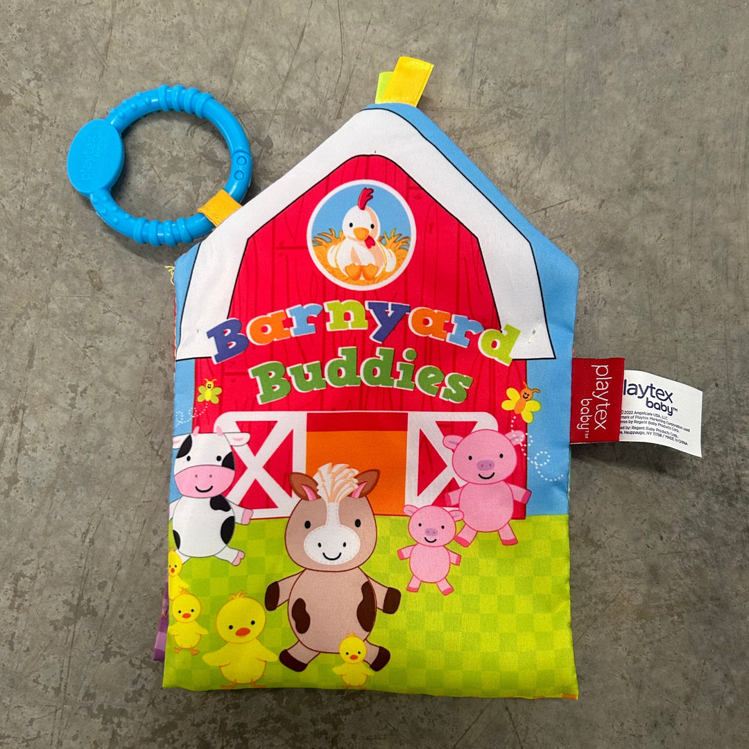 Children's book with farm animals and a blue ring toy on a gray surface