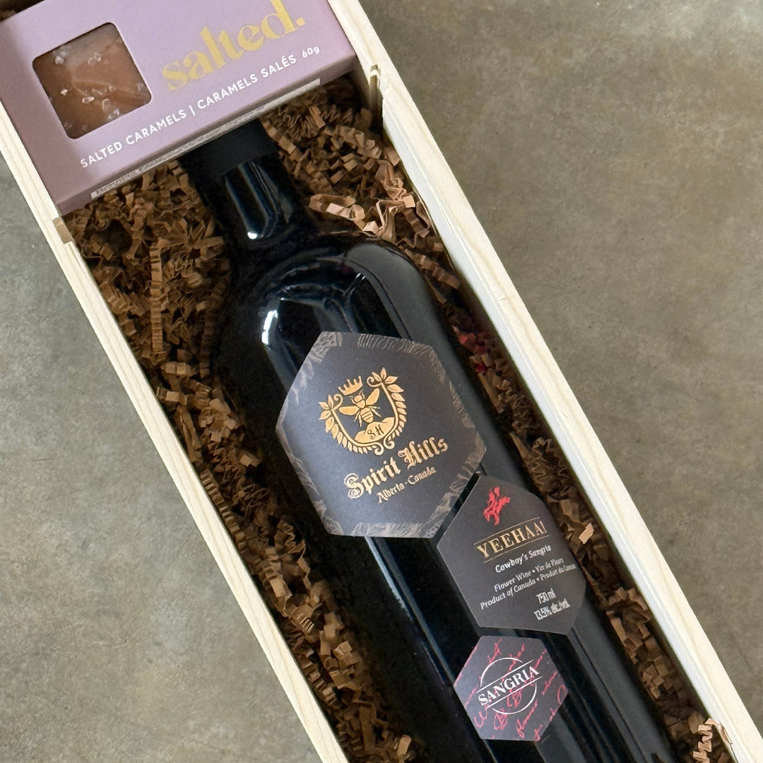 Two bottles of Perrier-Jouèts champagne in a wooden gift box on a concrete surface.