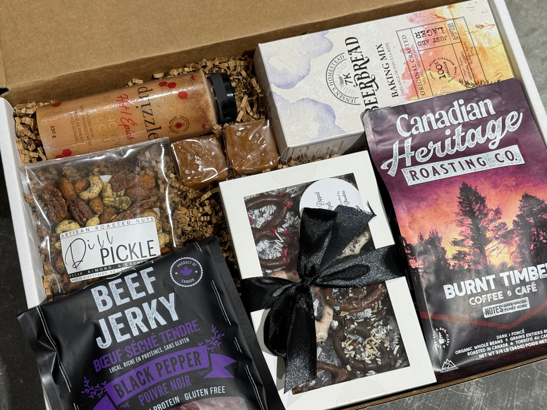 Gift box with beef jerky, coffee, and other snacks on a gray surface