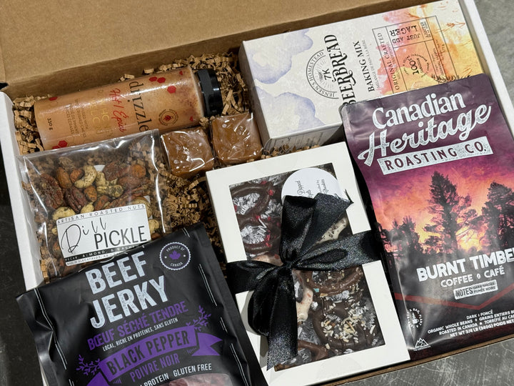 Gift box with beef jerky, coffee, and other snacks on a gray surface