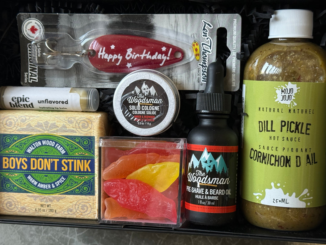 Collection of grooming and lifestyle products including a bottle, cologne, and other items on a gray surface.