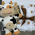 Cow-themed baby gift set with plush toy and burp cloths in a box.